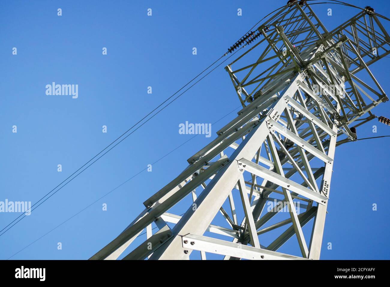 High voltage pole on blue sky background Stock Photo - Alamy