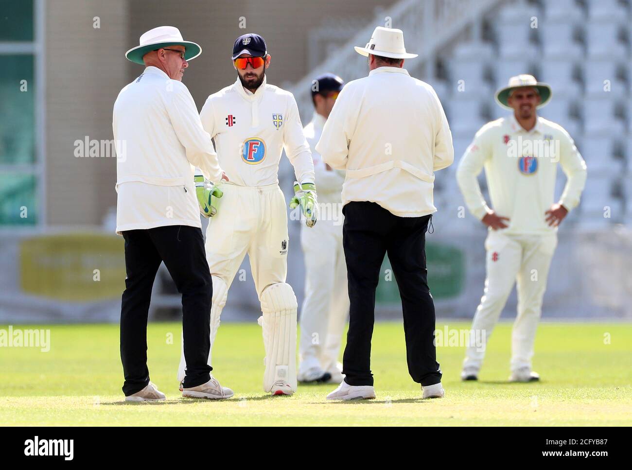 Match umpires speak with Durham's Ned Eckersley (centre) during day three of the Bob Willis Trophy match at Trent Bridge, Nottingham. Stock Photo