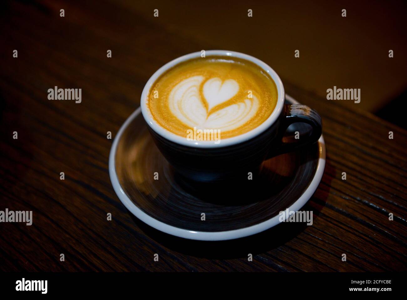 The cup of coffee latte with art on the wooden table Stock Photo - Alamy