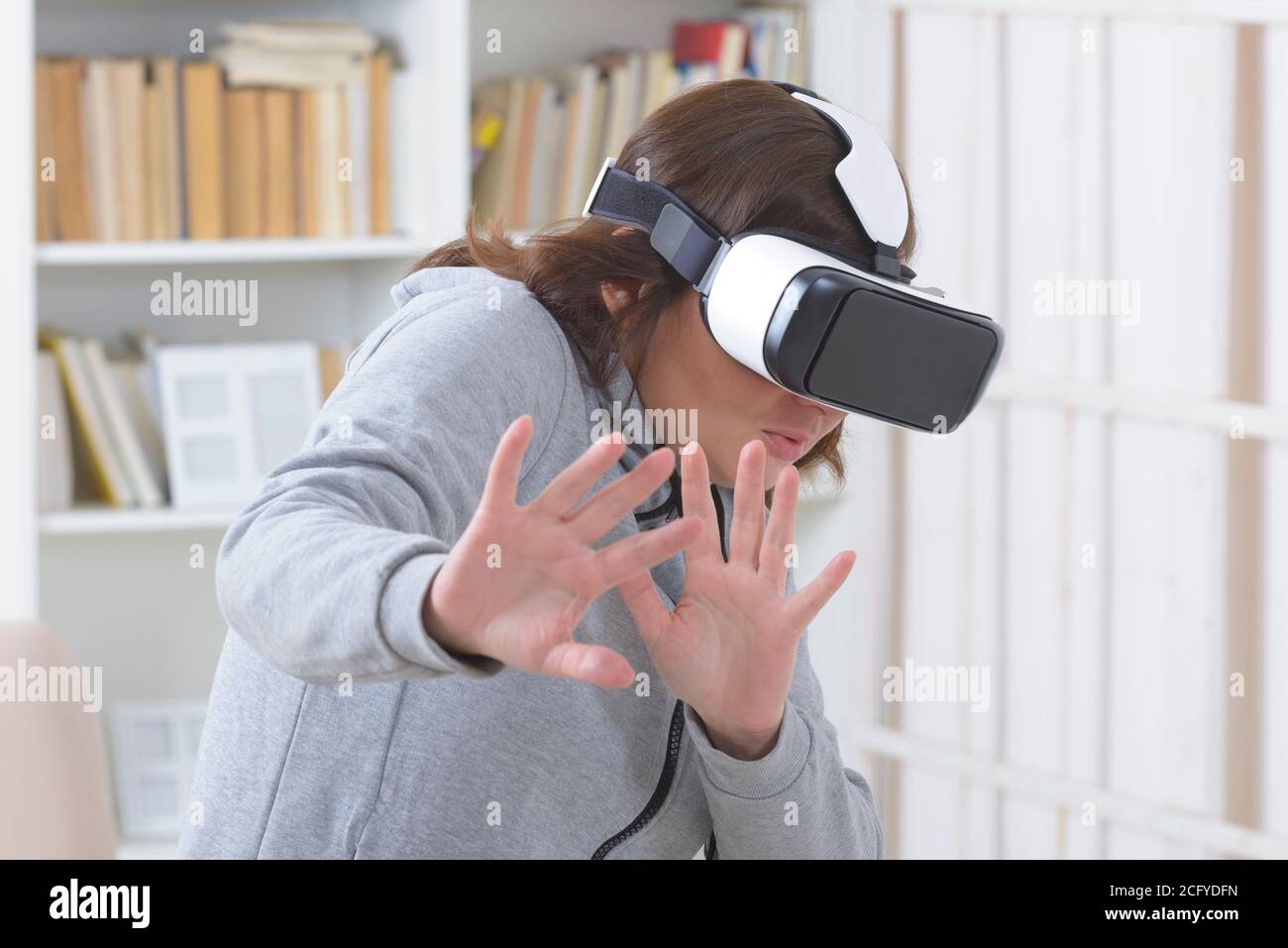Woman using virtual reality headset at home Stock Photo