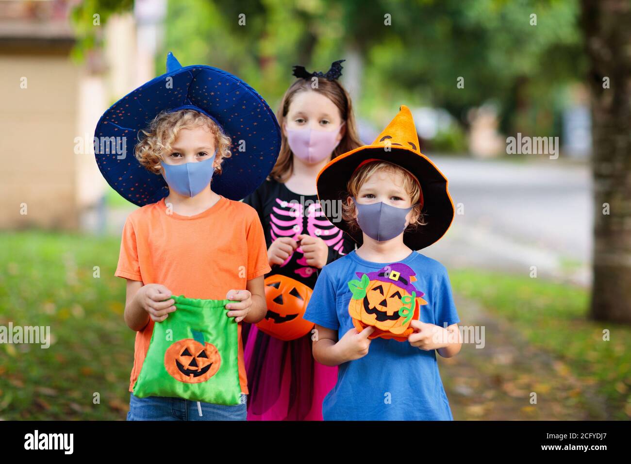 Kids trick or treat in Halloween costume and face mask. Children in