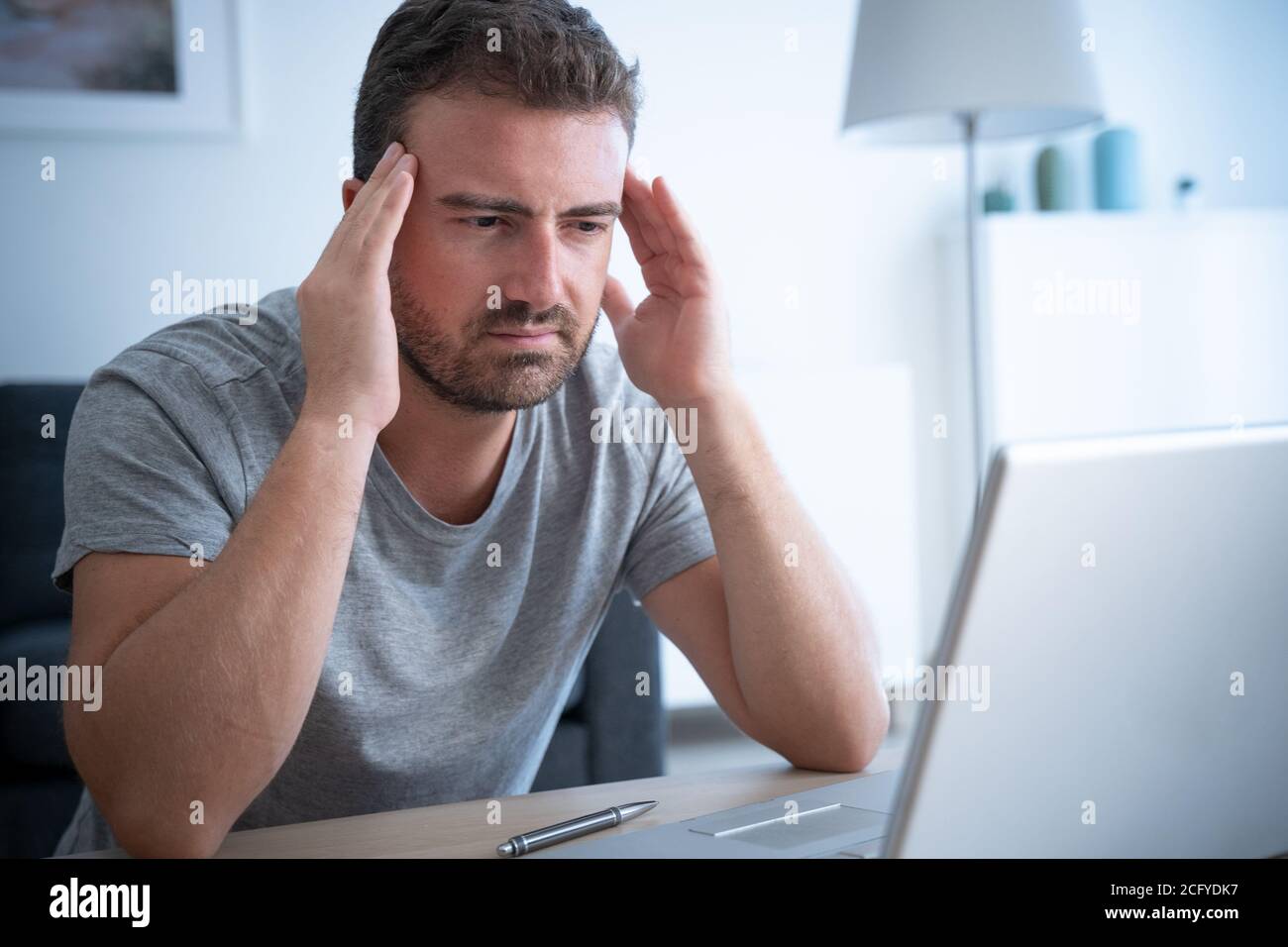 Man suffering head pain while using computer Stock Photo Alamy