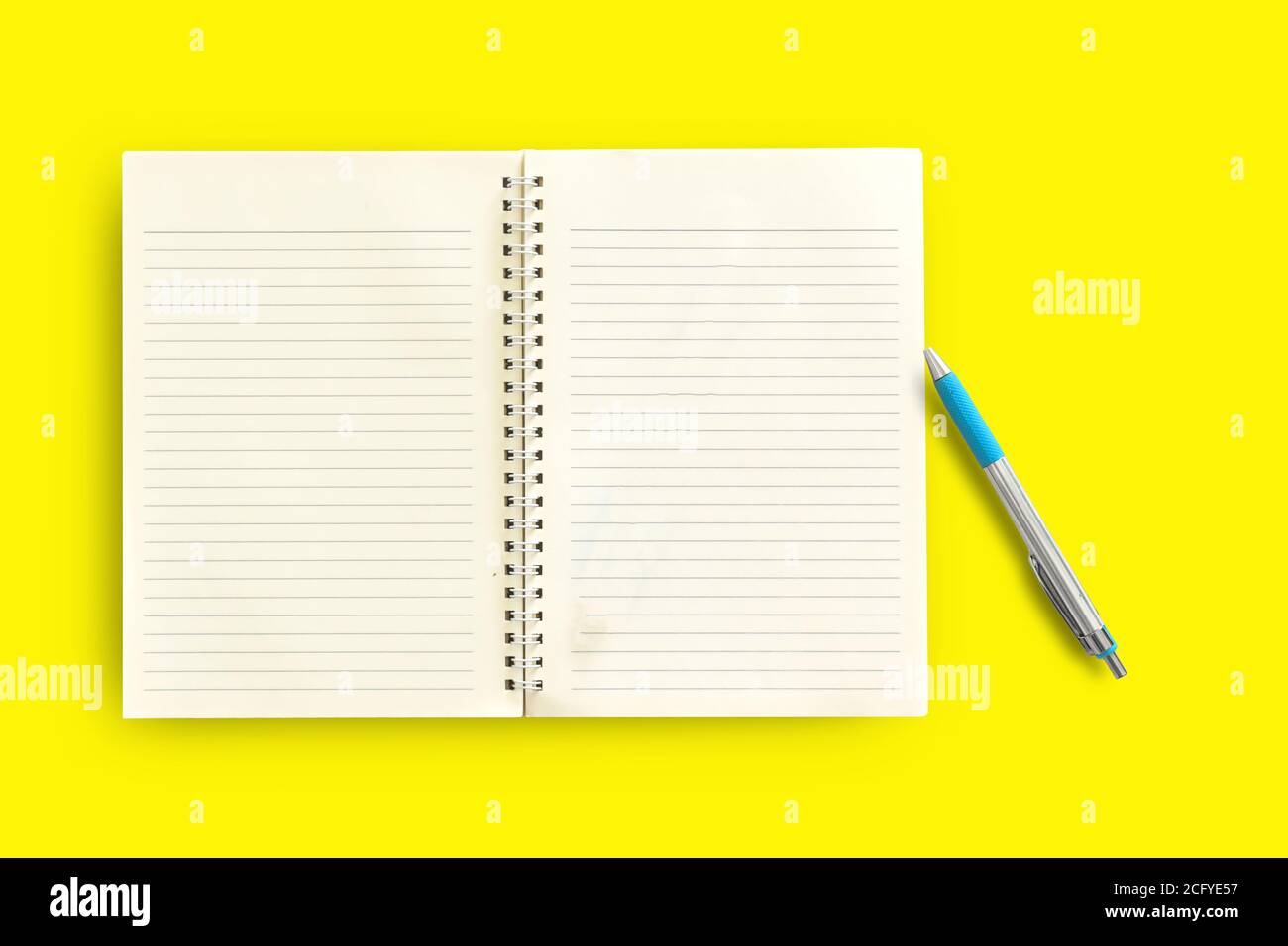 Notebook,pen on a yellow background. top view copy space Stock Photo