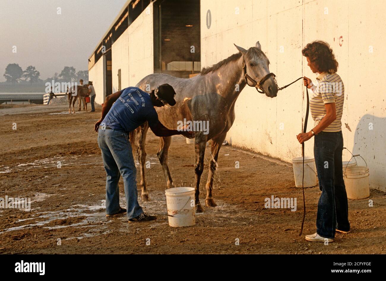 WASHING DOWN RACEHORSE AFTER STRENUOUS EXERCISE, CHURCHILL DOWNS, LOUISVILLE, KENTUCKY, USA, 1980s Stock Photo