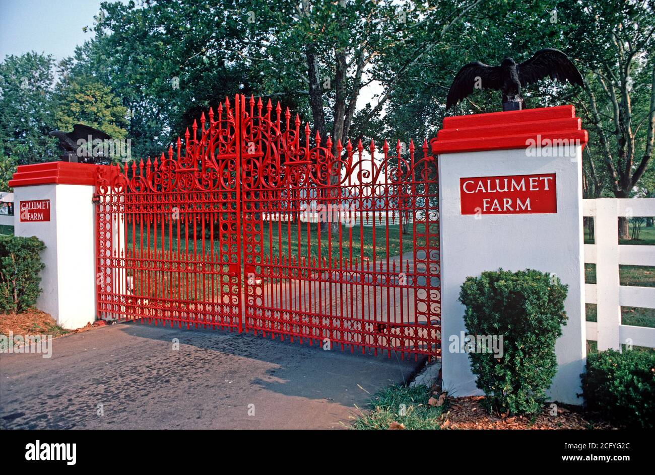 RED ENTRANCE GATES TO CALUMET THOROUGHBRED HORSE FARM, BLUEGRASS COUNTRY, KENTUCKY, USA, 1980s Stock Photo