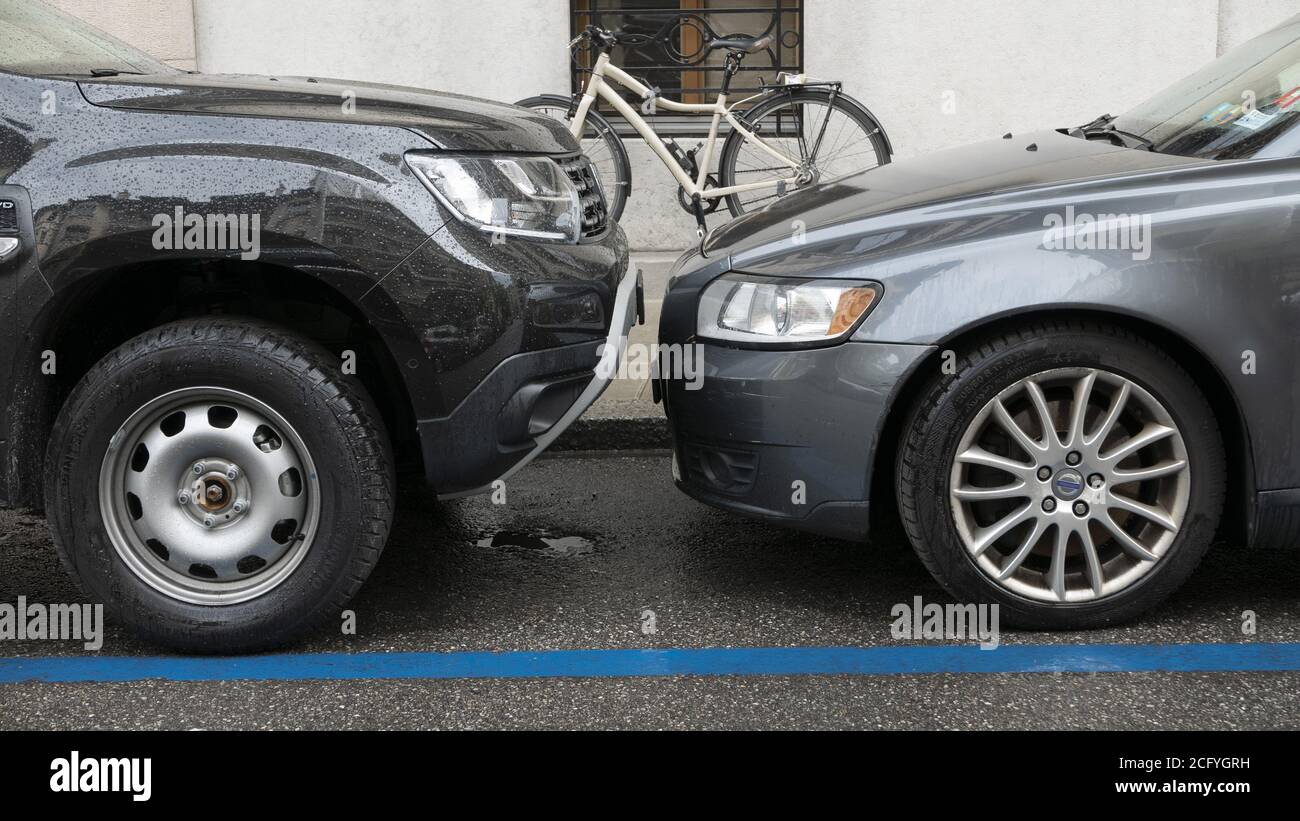 2 anonymous cars parked very close and facing each other Stock Photo