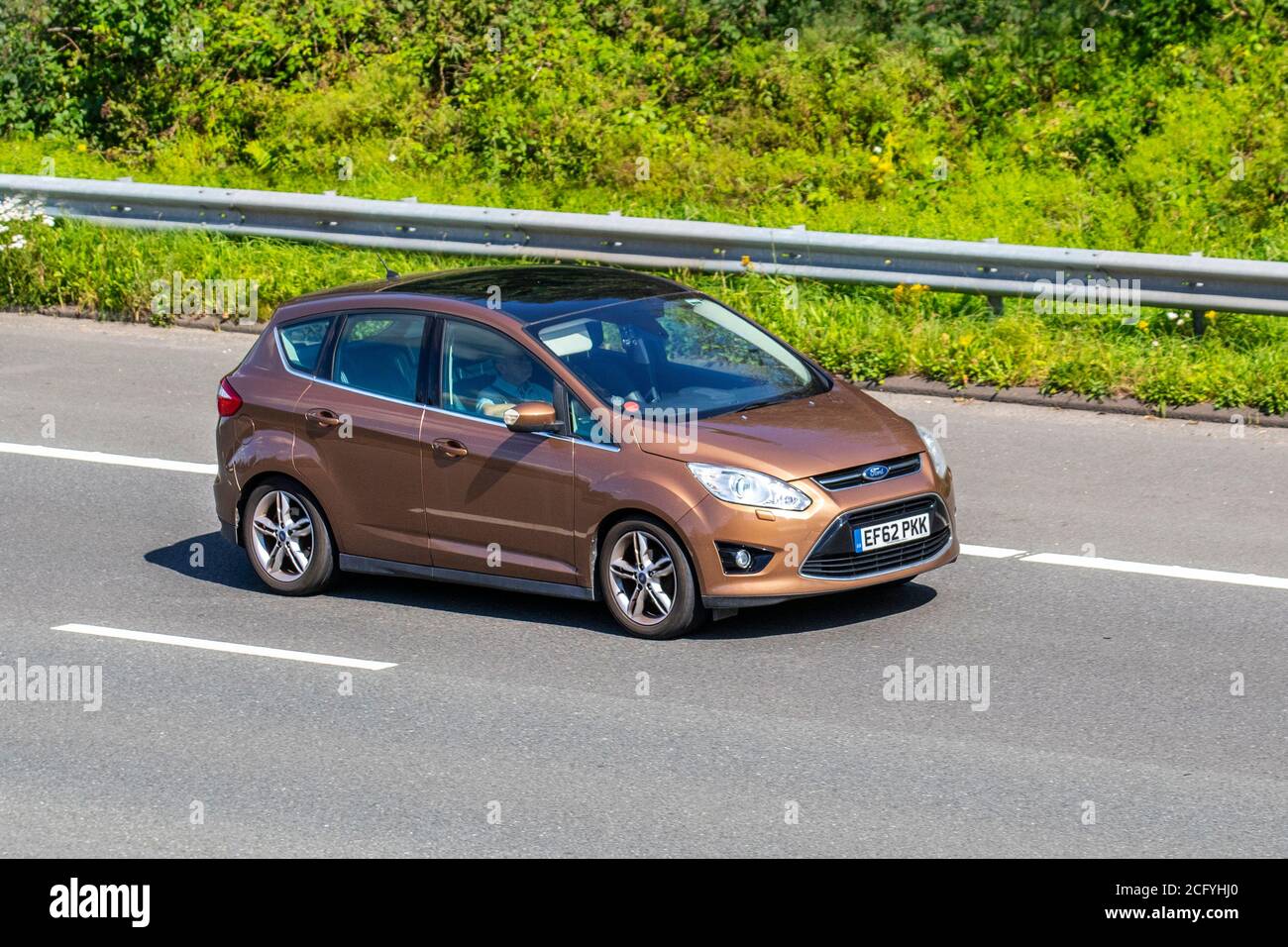 2012 brown Ford C-Max Titanium X TDCI; Vehicular traffic moving vehicles, cars driving vehicle on UK roads, motors, motoring on the M6 motorway highway network. Stock Photo