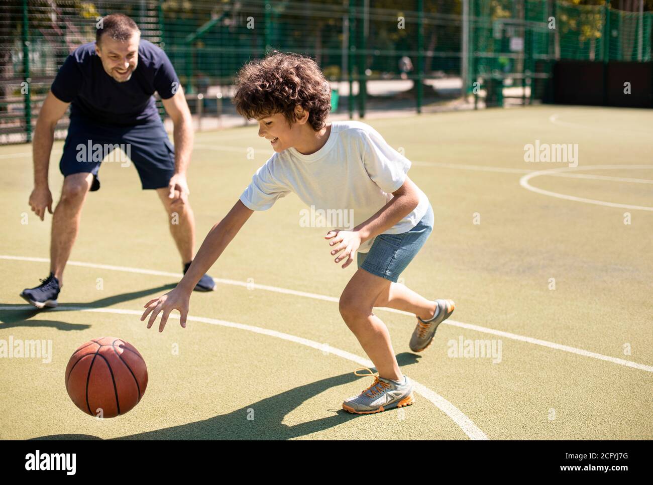 Coach teaching boy how to play basketball Stock Photo Alamy