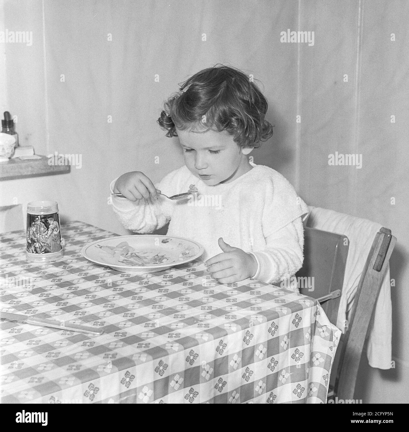 Toddler eating at kitchen table, 1950s, USA Stock Photo