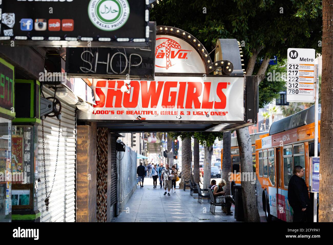 Deja Vu Showgirls strip club front entrance canopy on hollywood Boulevard, Los Angeles California, USA. Bus stop and people. Stock Photo