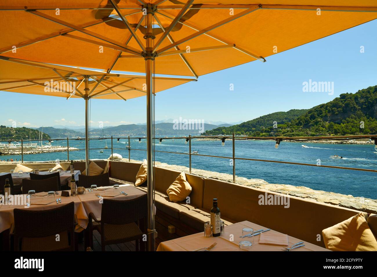 A terrace restaurant with a scenic view on the Gulf of Poets and the Palmaria Island in a sunny summer day, Porto Venere, La Spezia, Liguria, Italy Stock Photo