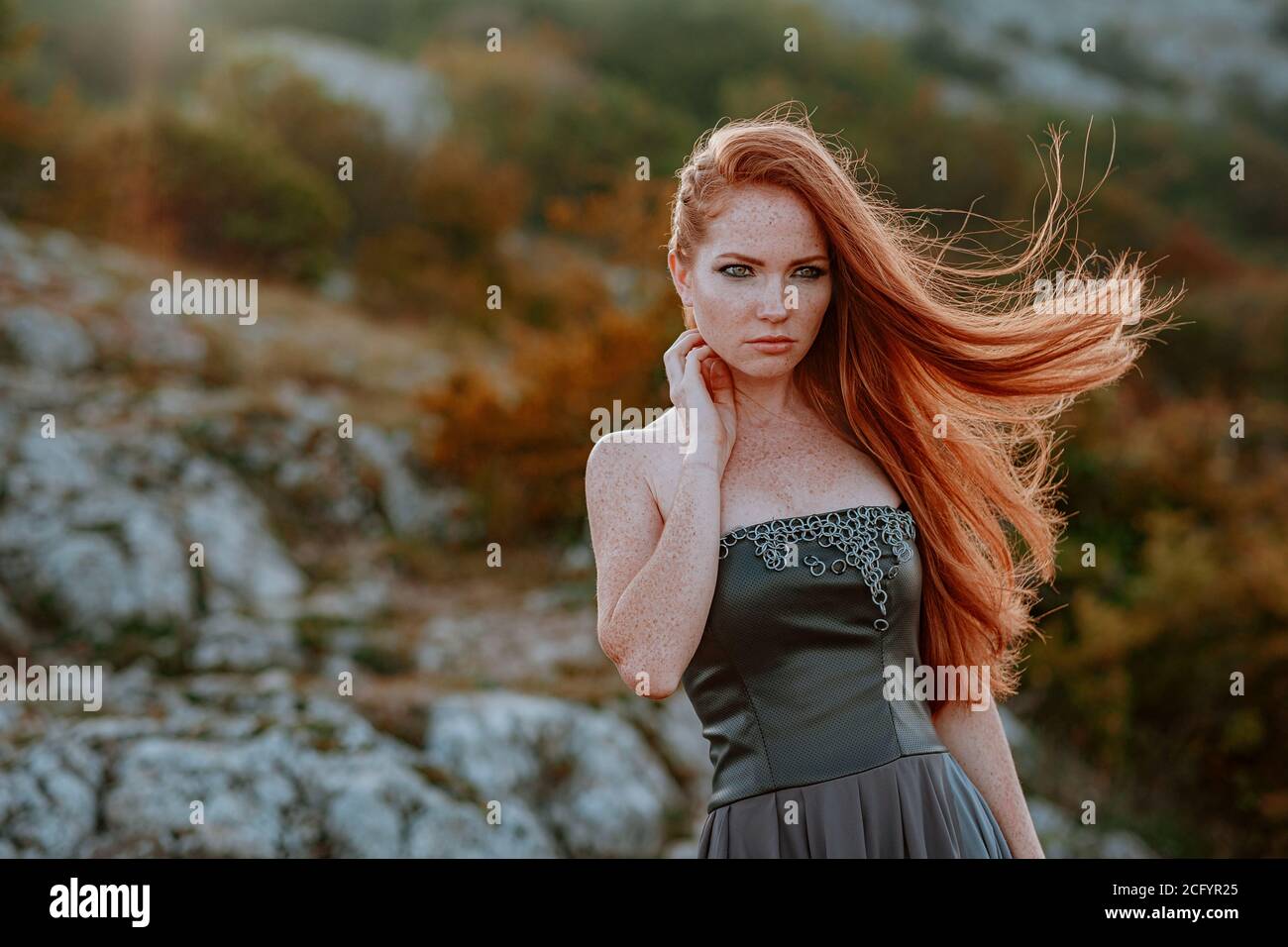 beautiful furious scandinavian warrior ginger woman in grey dress with metal chain mail. Woman is a Viking. Fantasy. Book Cover Stock Photo