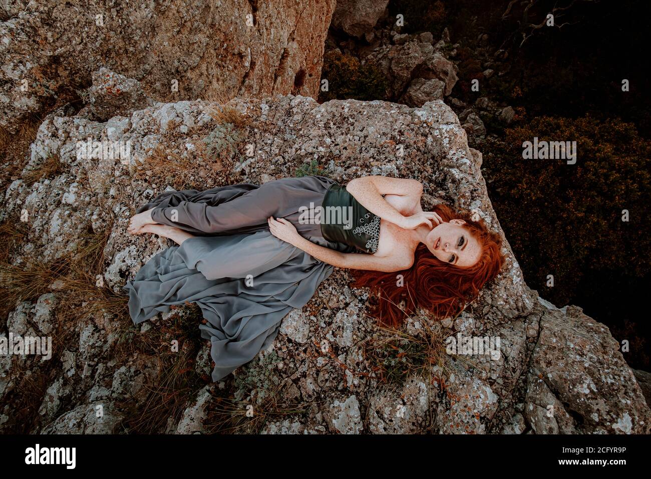 beautiful furious scandinavian warrior ginger woman in grey dress with metal chain mail. Woman is a Viking. Fantasy. Book Cover Stock Photo