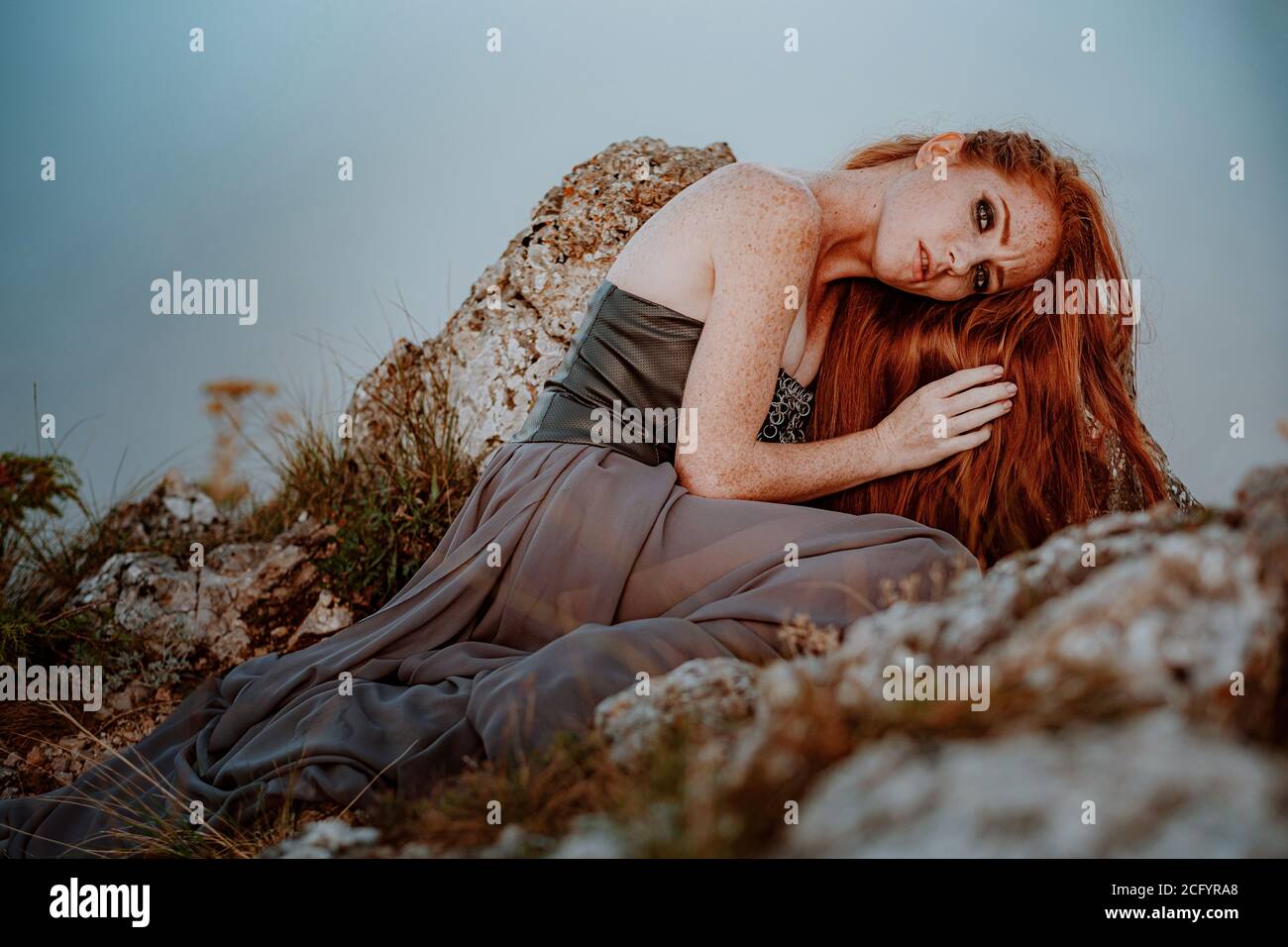 beautiful furious scandinavian warrior ginger woman in grey dress with metal chain mail. Woman is a Viking. Fantasy. Book Cover Stock Photo