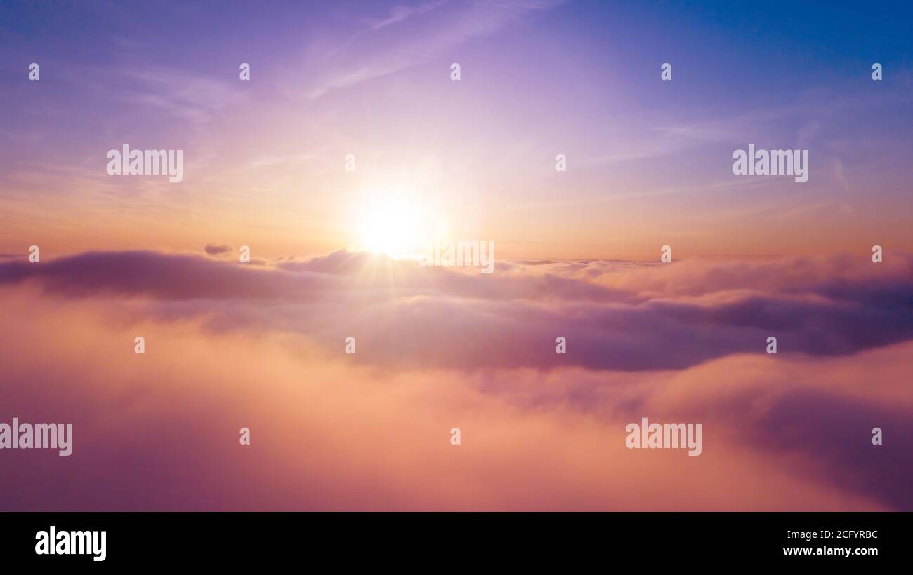 Beautiful sunset cloudy sky from aerial view. Airplane view above clouds Stock Photo