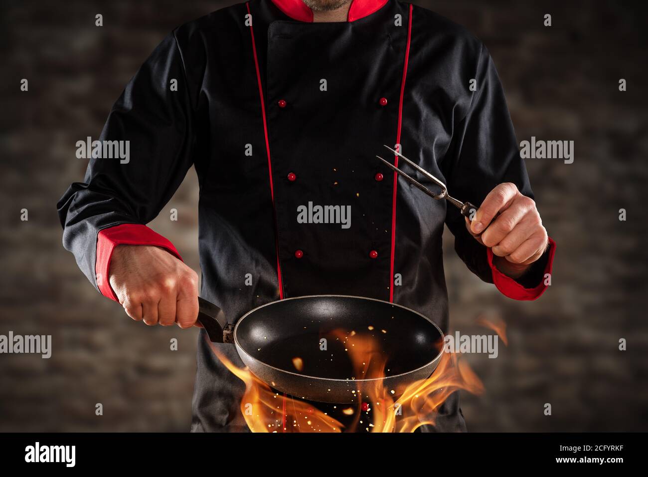 Closeup of chef holding empty frying pan above grill. Concept of food preparation, ready for product placement. Stock Photo