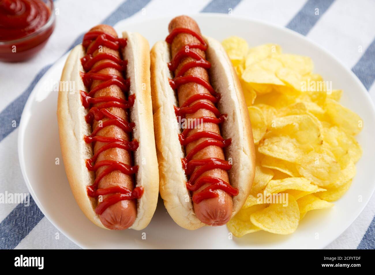 Tasty American Hot Dog with Potato Chips on a white plate side view. Close up Stock Photo Alamy