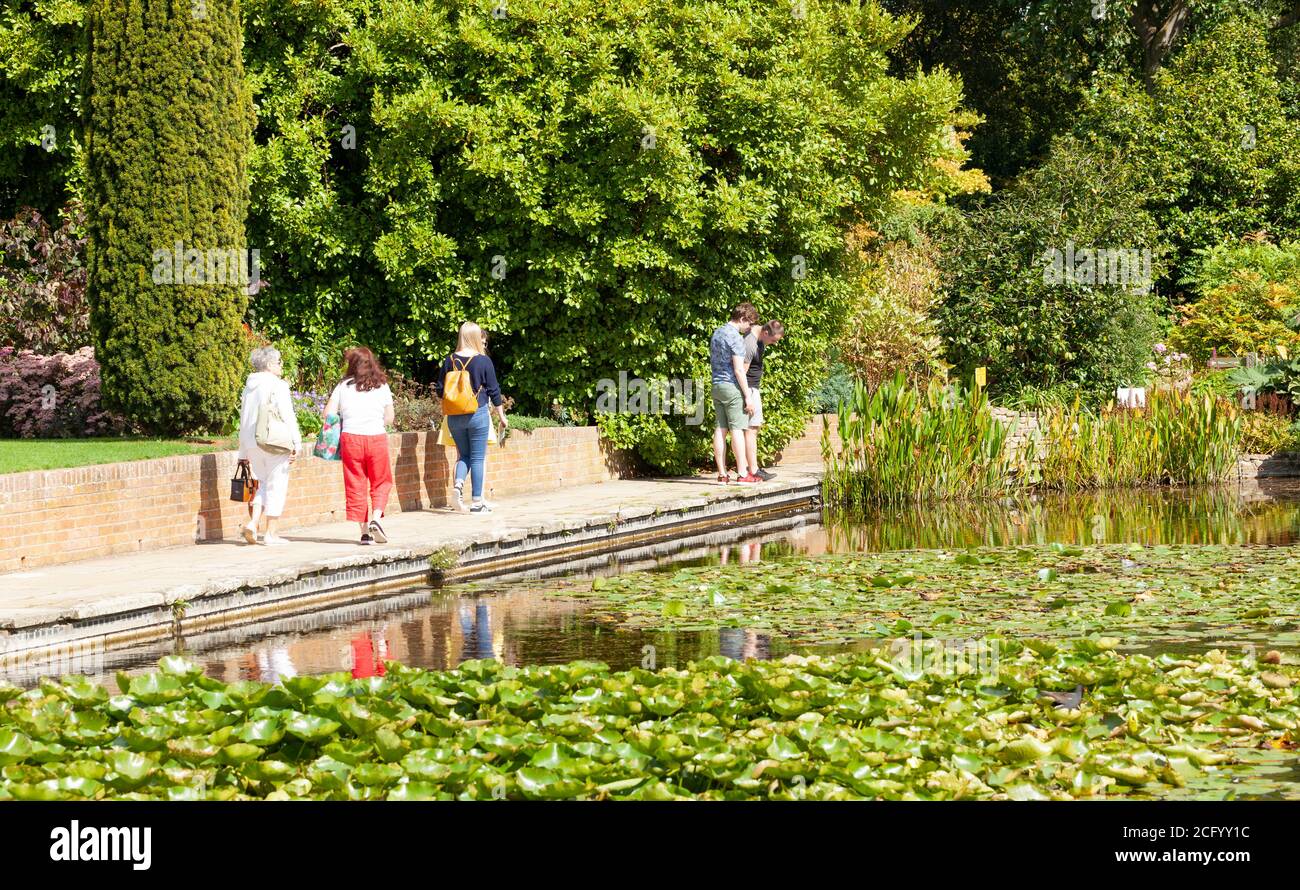 Group of people mixed ages in beautiful UK gardens at RHS Hyde Hall Essex. Stock Photo