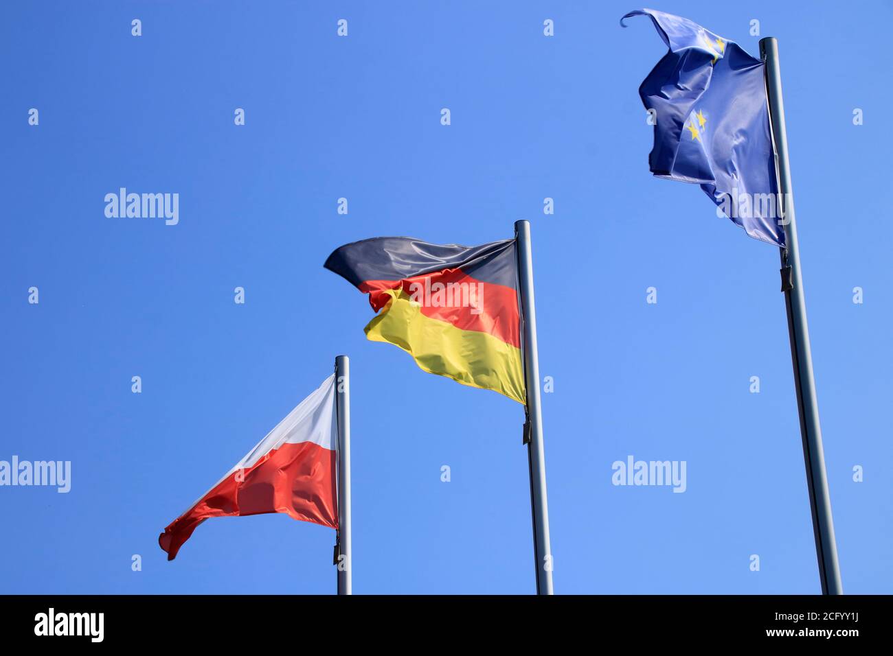 Flags blow in the wind against a blue sky Stock Photo