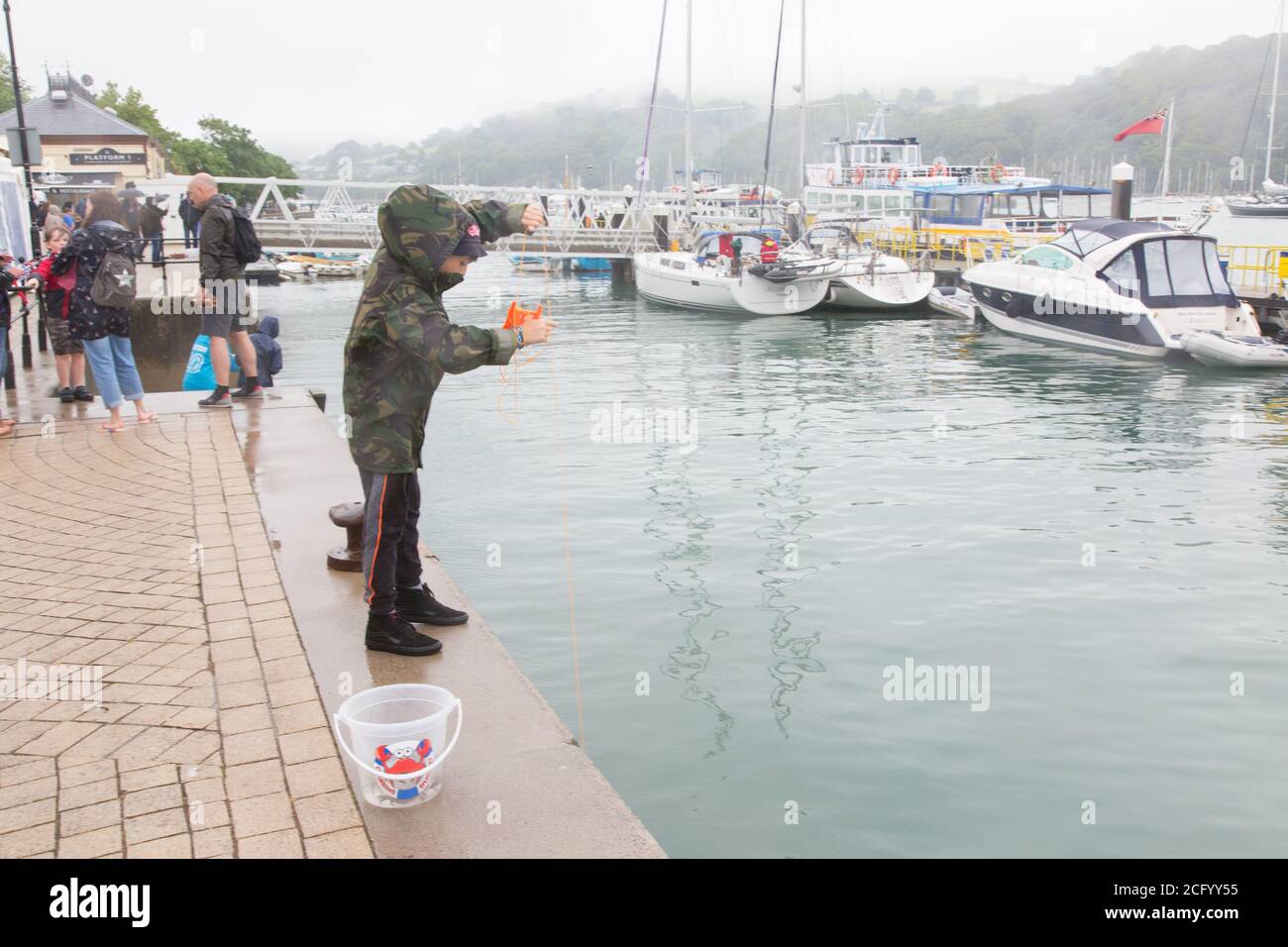 Eleven year old boy fishing for crabs Dartmouth, Devon, England, United Kingdom. Stock Photo
