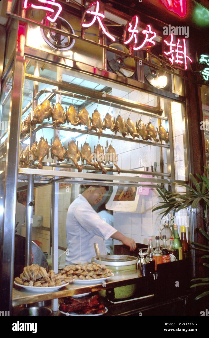 Hong Kong China Chinese Asians Kowloon,restaurant restaurants cook cooking window,display sale night,duck chicken food,man men male,neon sign characte Stock Photo