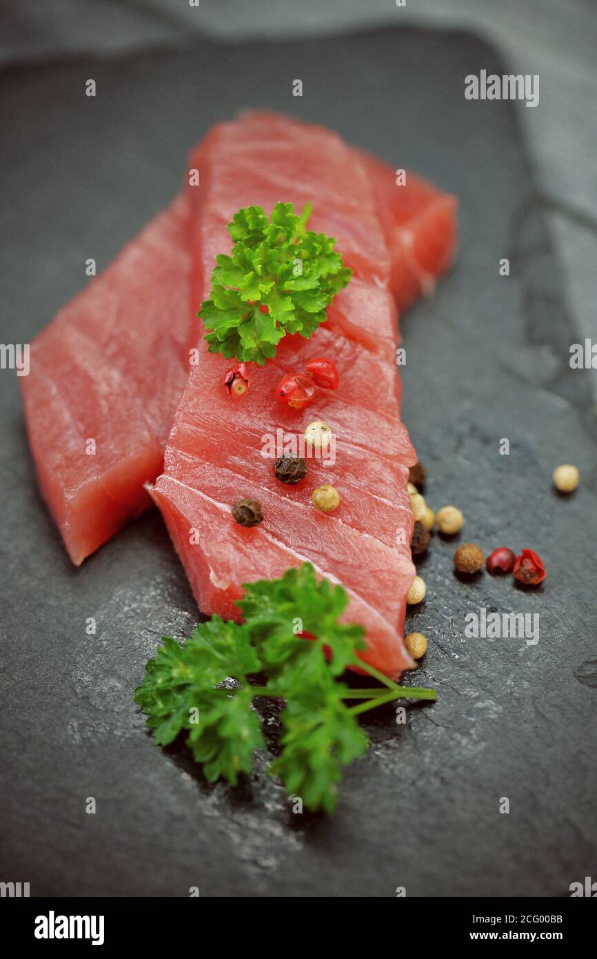 Raw tuna fillet on a black stone background Stock Photo