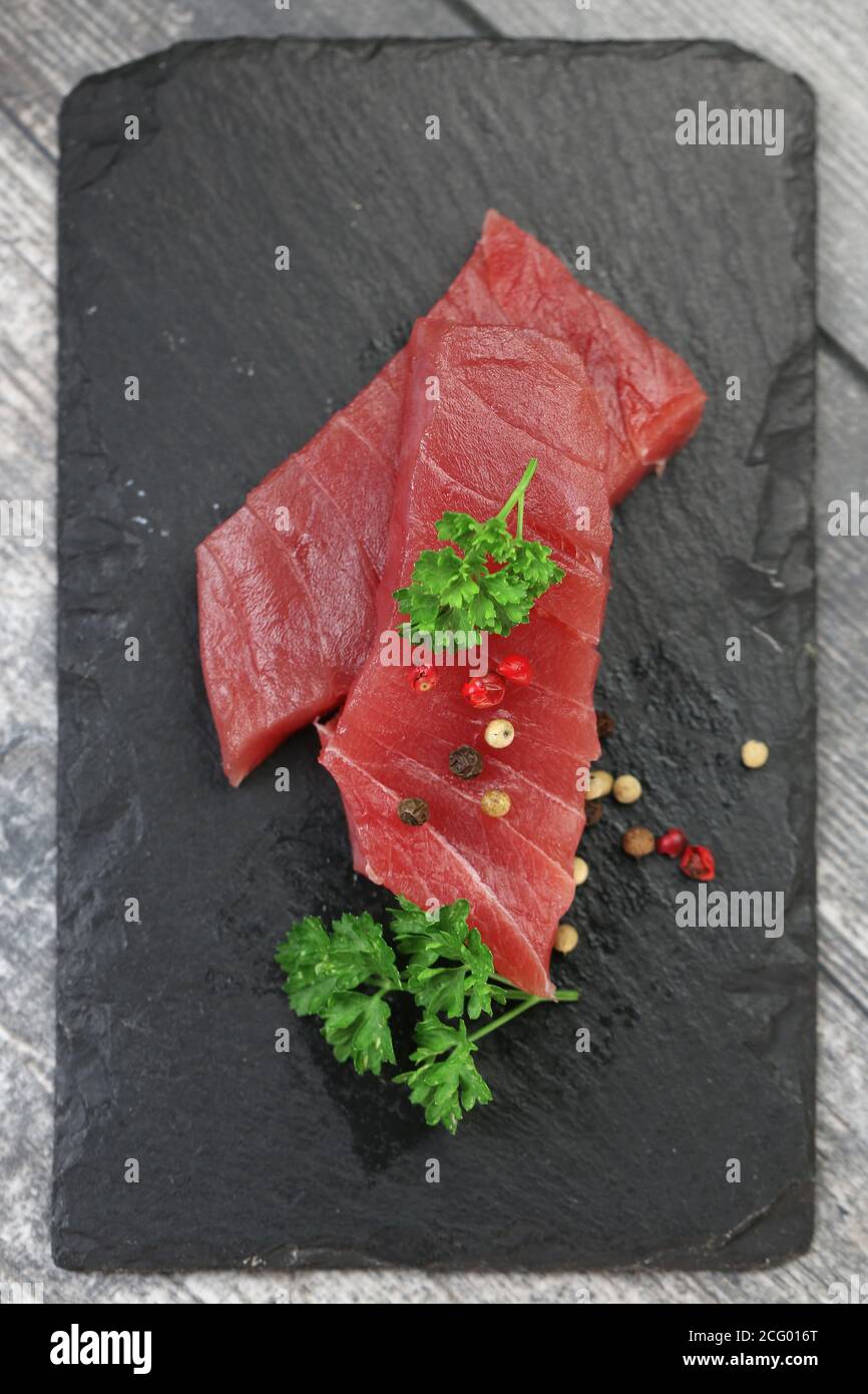 Raw tuna fillet on a black stone background Stock Photo