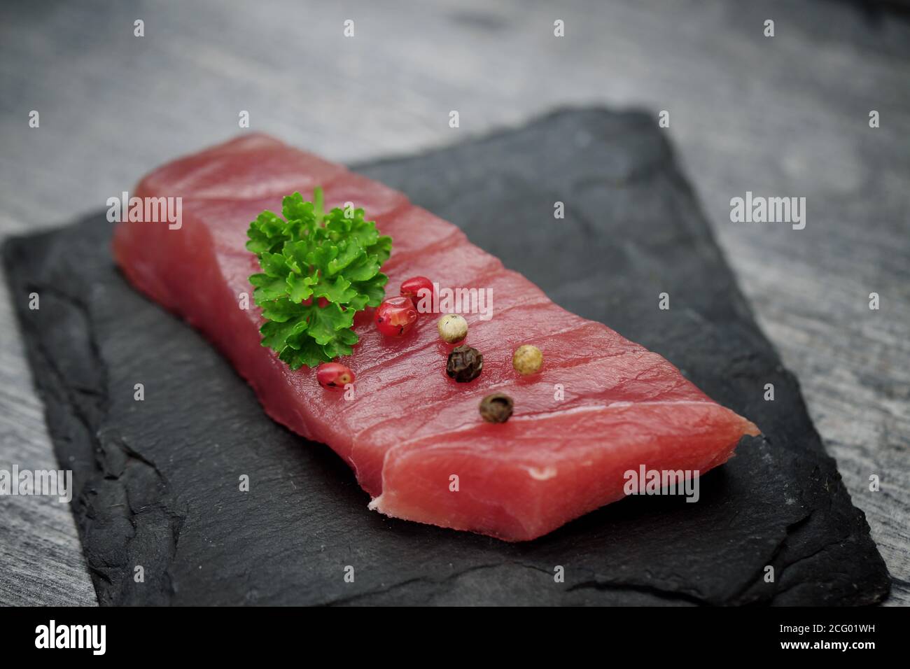 Raw tuna fillet on a black stone background Stock Photo