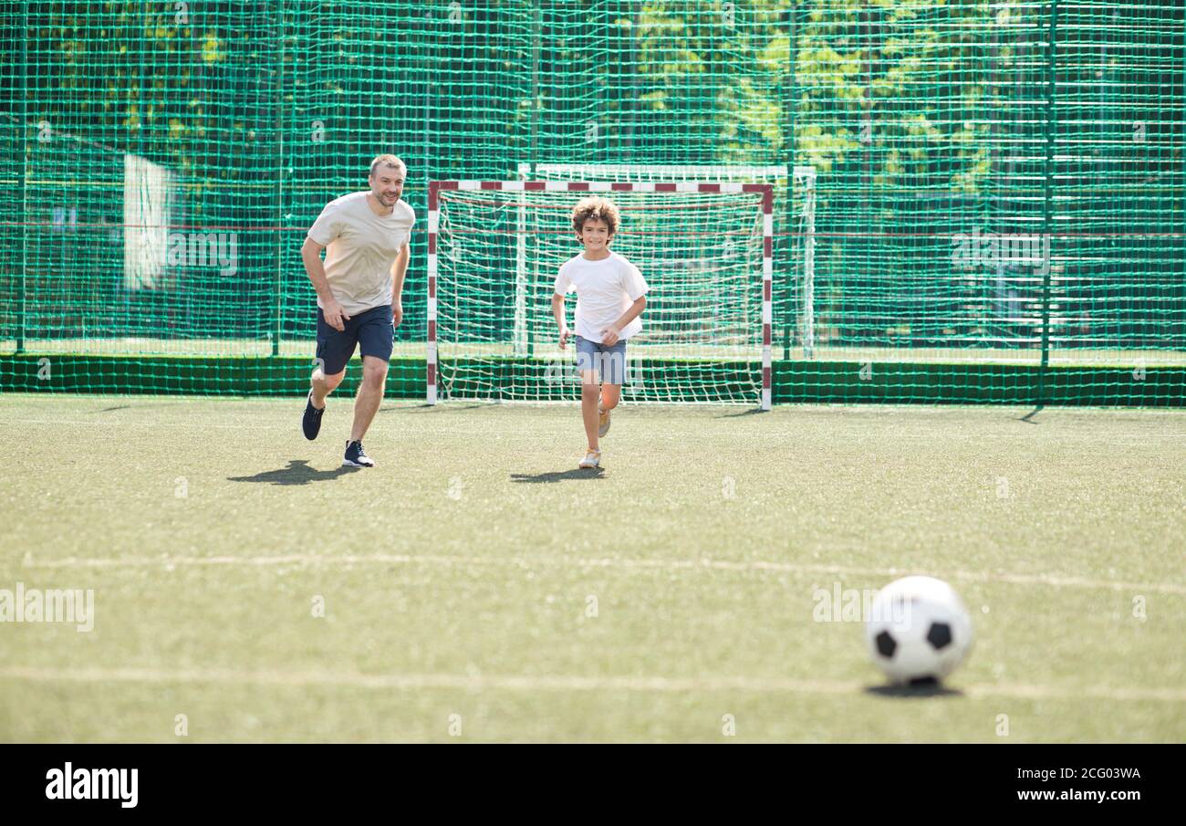 Sportive dad playing football with his son Stock Photo