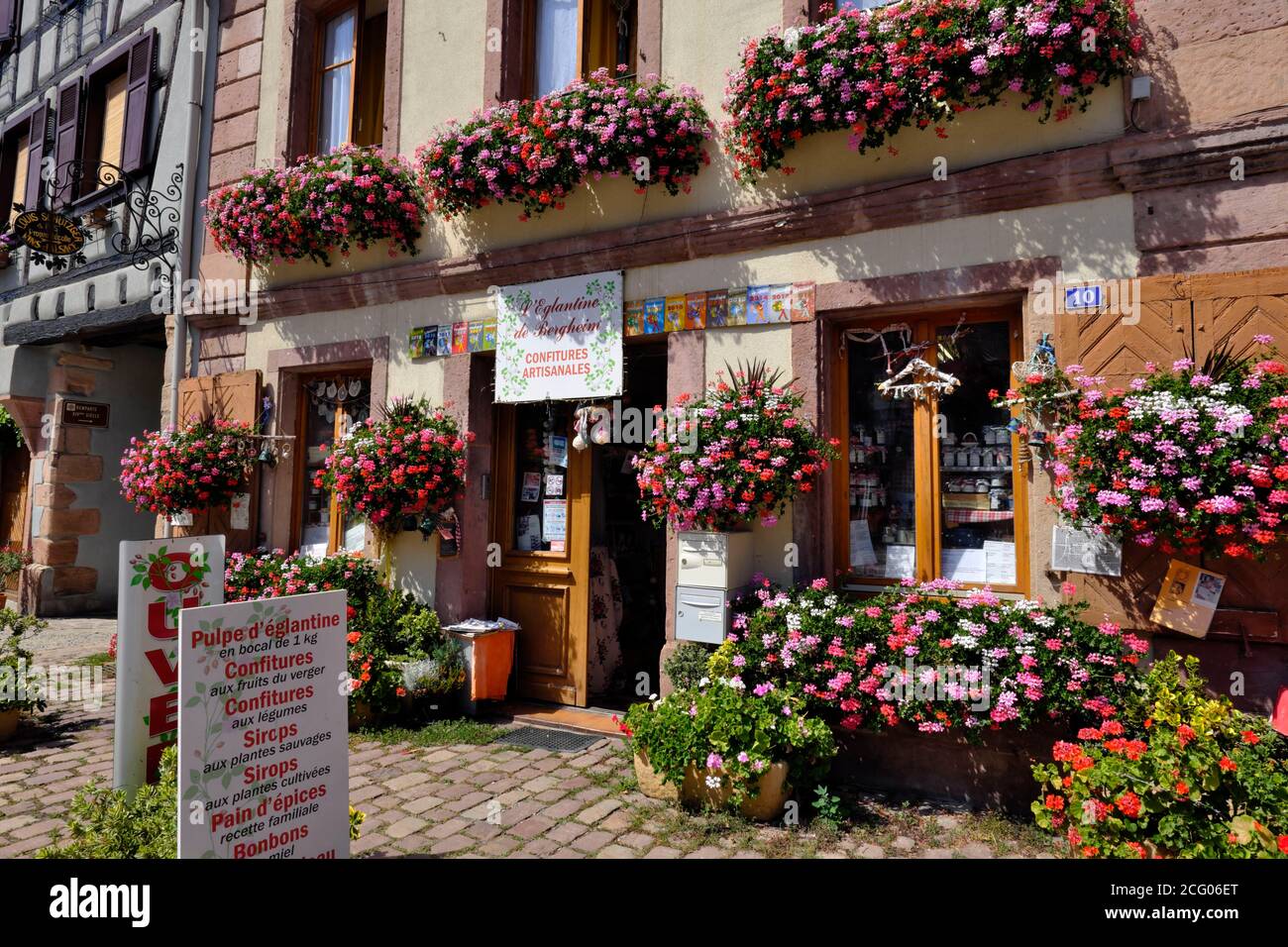 France, Haut Rhin, Bergheim, Place du Dr Pierre Walter, L Eglantine de Bergheim, grocery store, homemade jams, shop facade, flowers, geranium Stock Photo