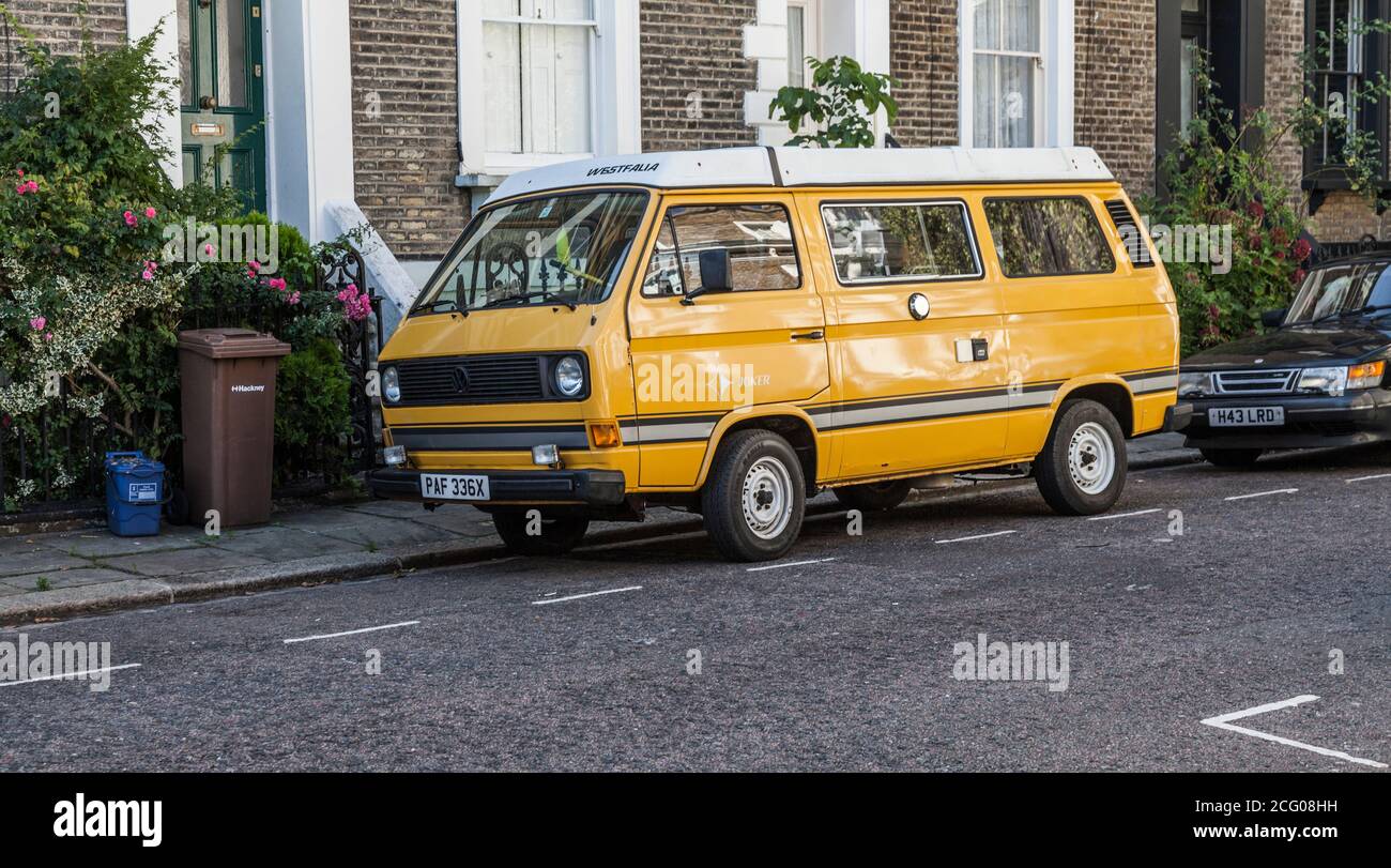 A yellow and white coloured VW camper van parked in a street in Hackney,London,England,UK Stock Photo