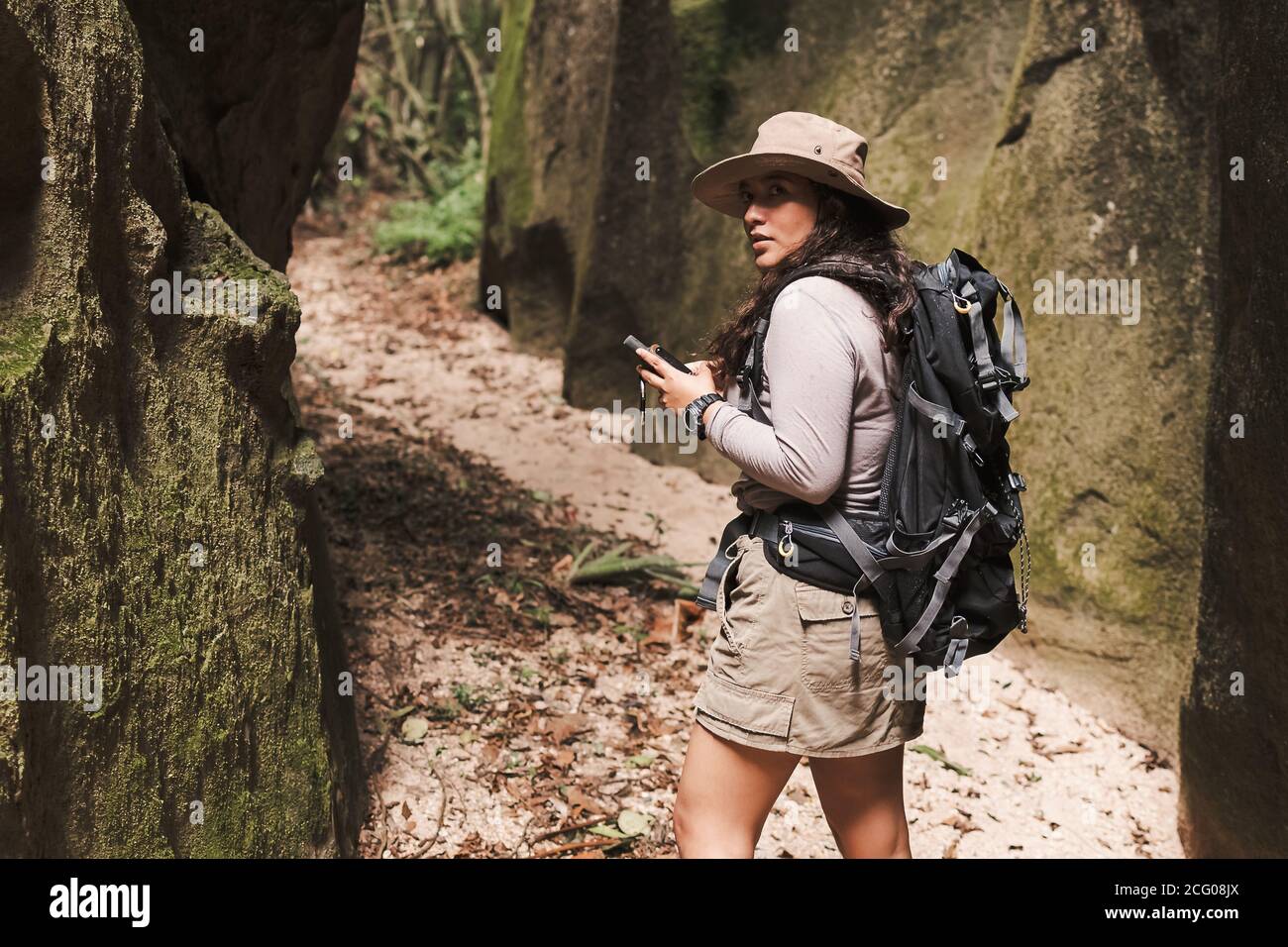 Woman with gps and backpack looking back. Stock Photo