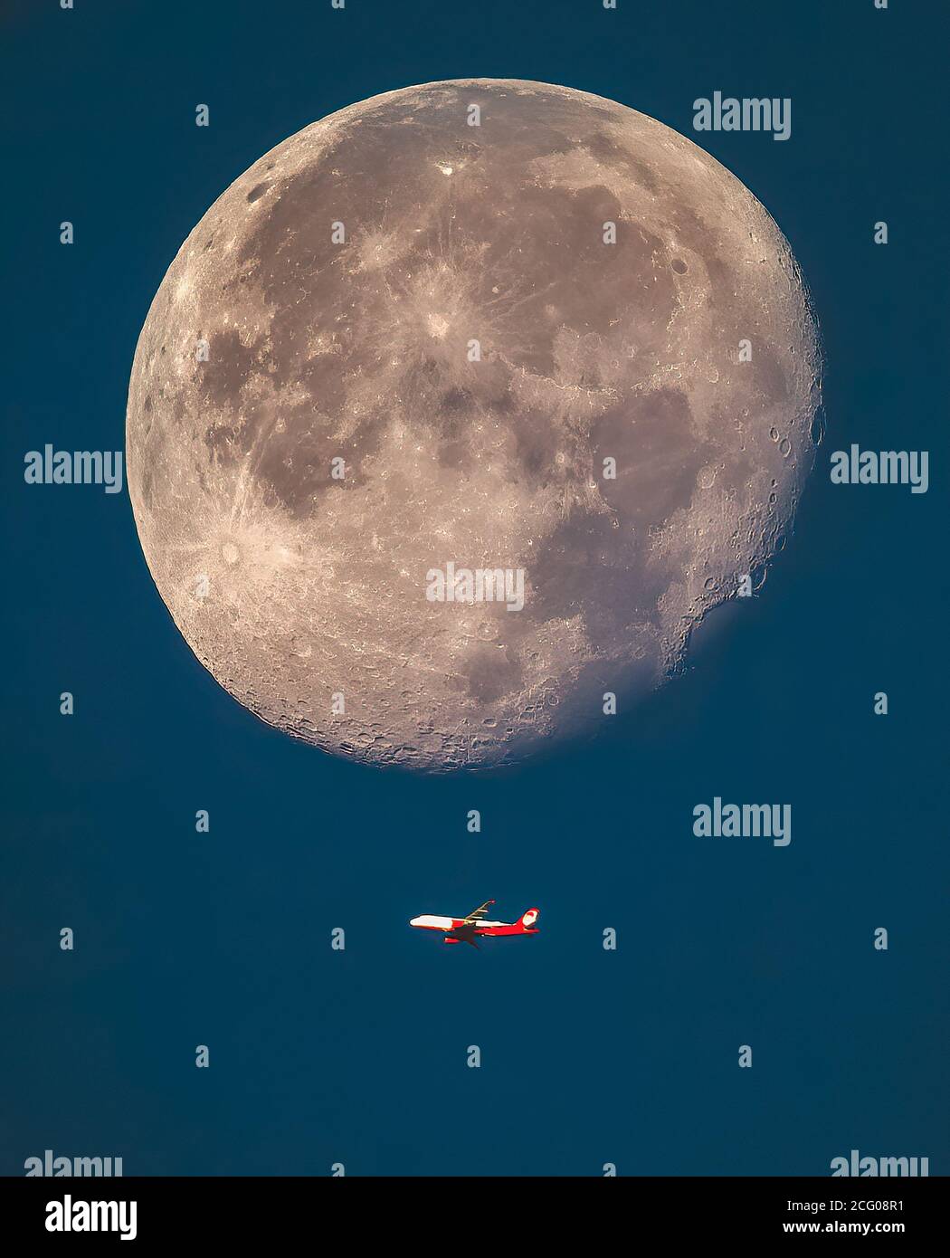 airliner flies just below the big moon, the best photo Stock Photo