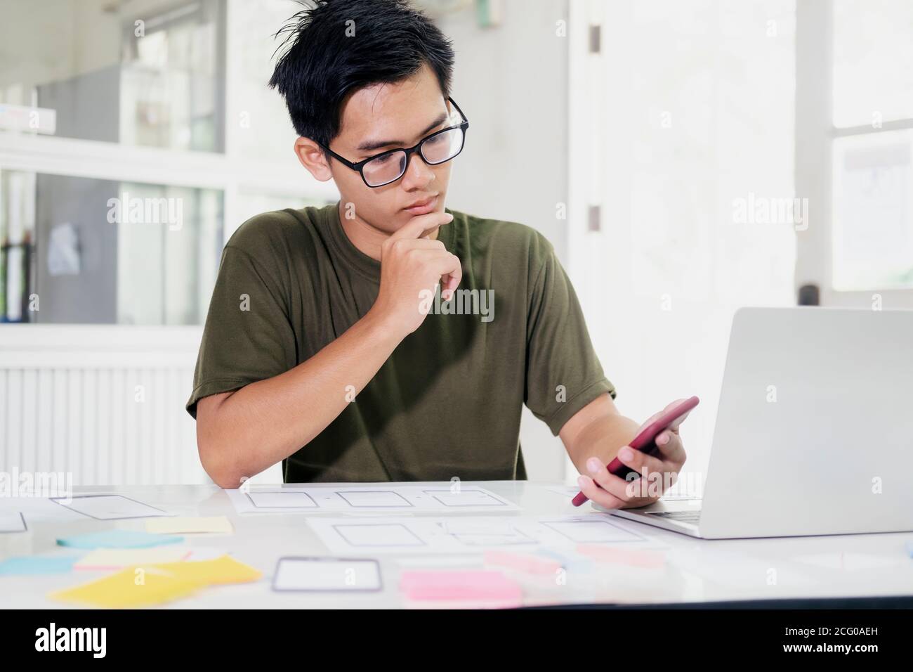 Web designer, UX UI designer designing mobile application user interface. Creative planning application development sketch layout wireframe design. Stock Photo