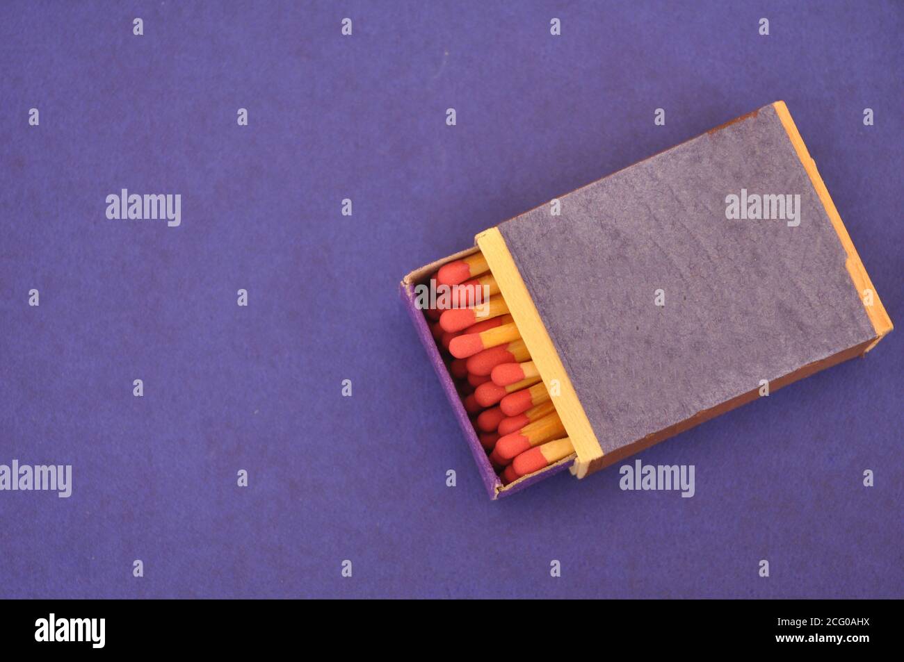 Matchbox, wooden, matchsticks with red head in a half-open box, on a blue background, with copy space Stock Photo