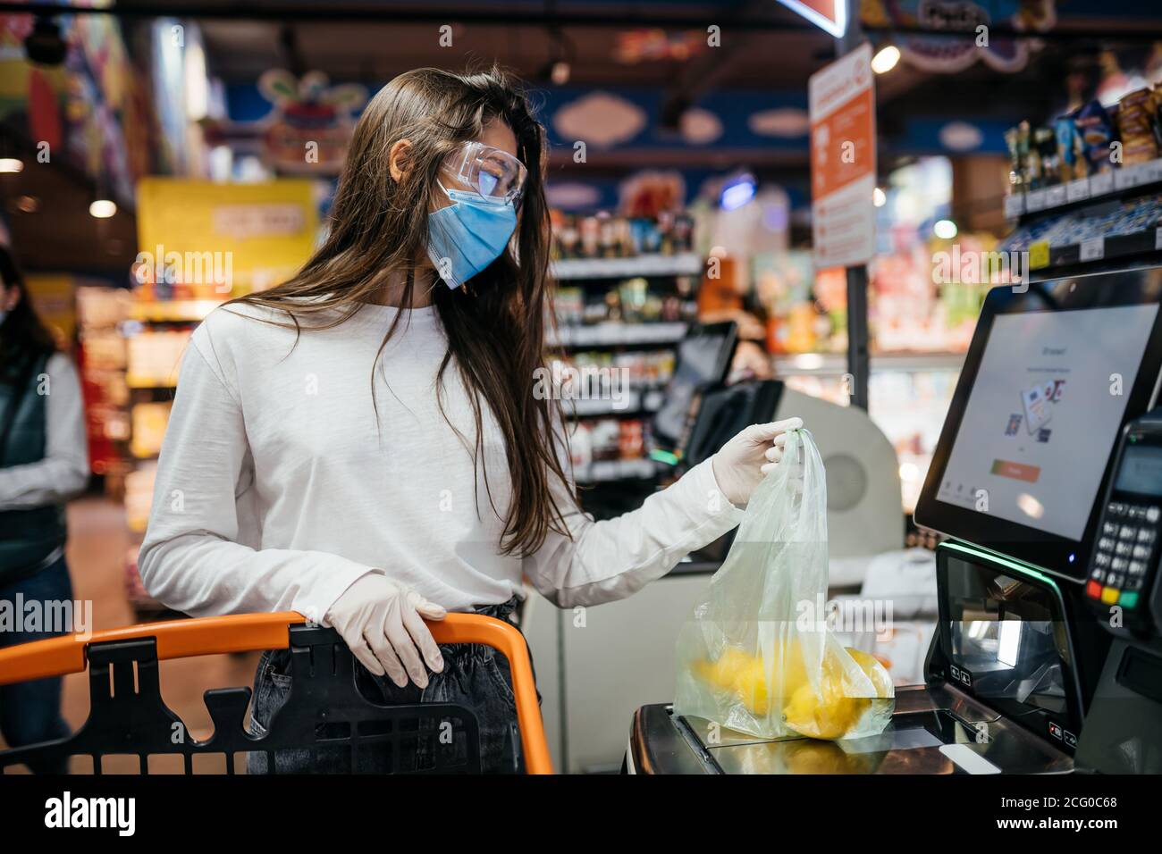 A young woman scans products in a mask and gloves Stock Photo - Alamy