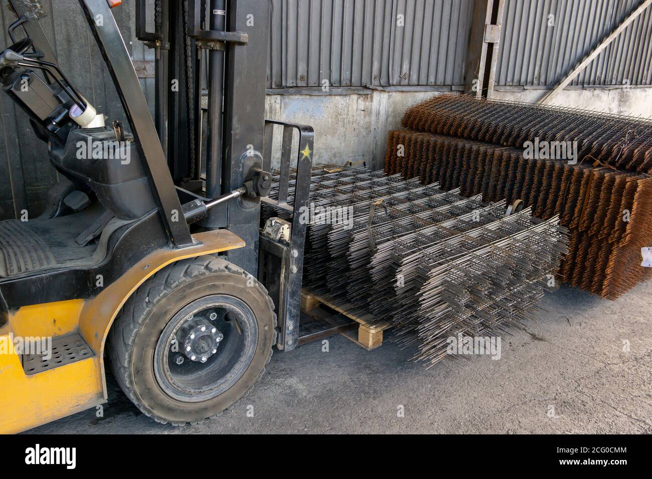 warehouse forklift carrying a stack of rebar mesh Stock Photo