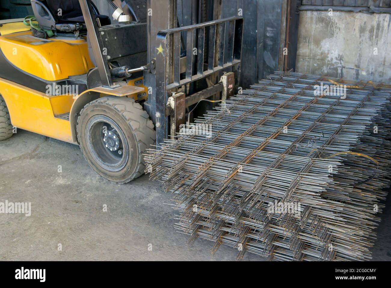 warehouse forklift carrying a stack of rebar mesh Stock Photo