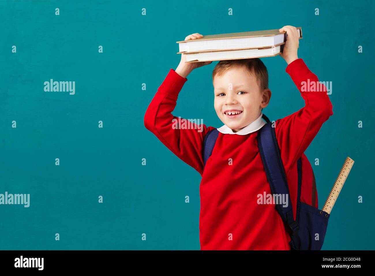 Cheerful thoughtful little school boy in school uniform with backpack ...