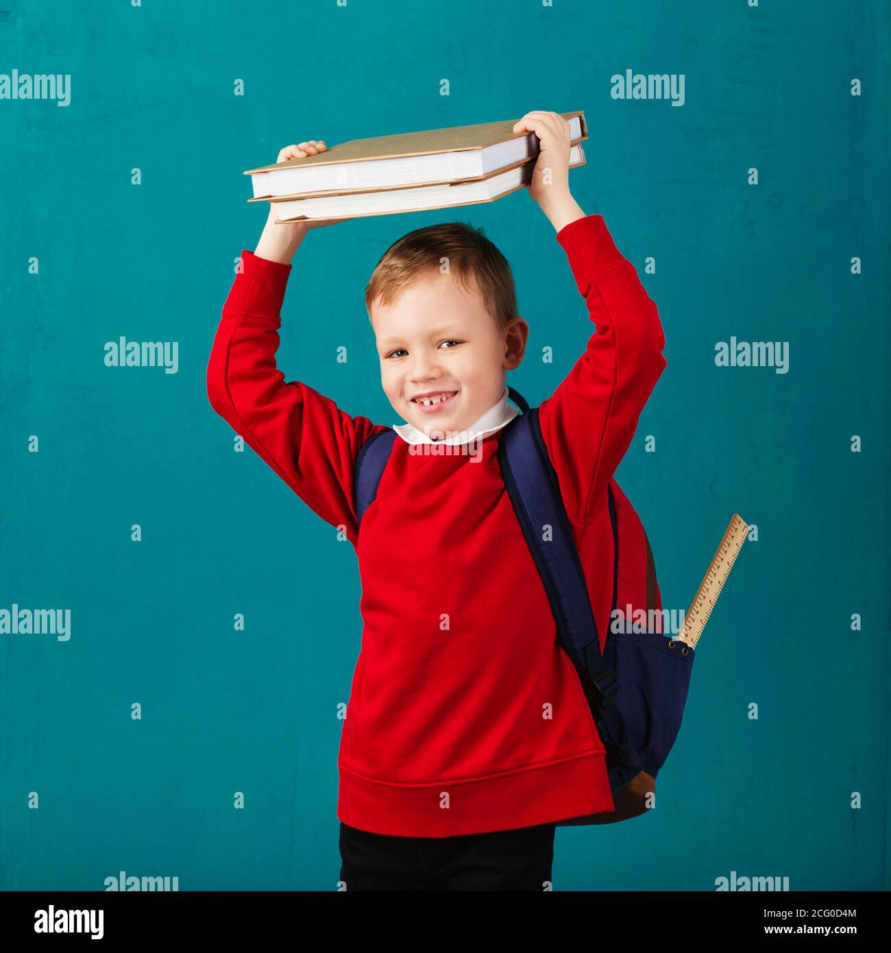Cheerful thoughtful little school boy in school uniform with backpack ...