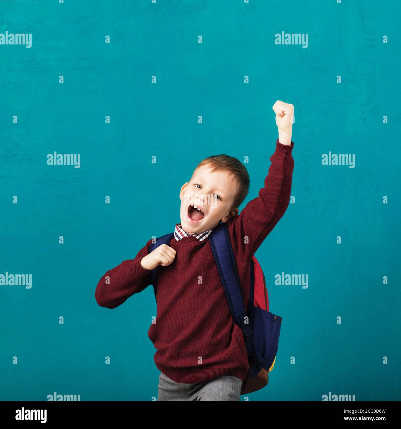 Cheerful smiling little school boy with big backpack jumping and having ...