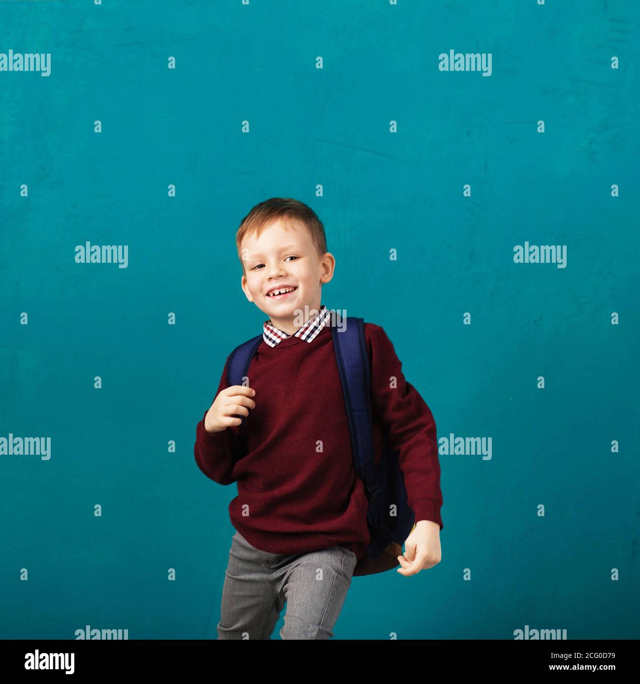 Cheerful smiling little school boy with big backpack jumping and having ...