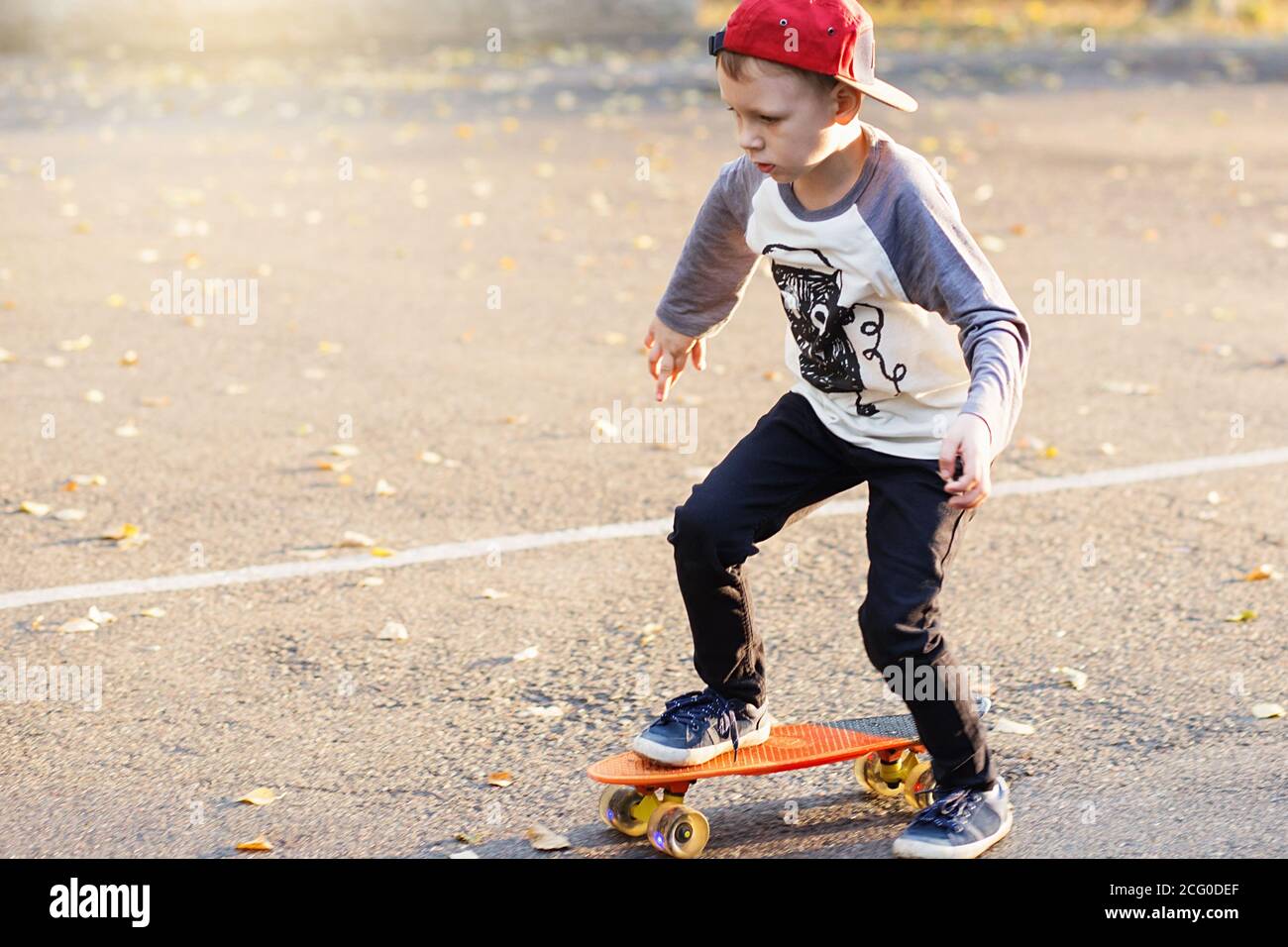 Little urban boy with a penny skateboard. Young kid riding in the park on a  skateboard. City style. Urban kids. Child learns to ride a penny board  Stock Photo - Alamy