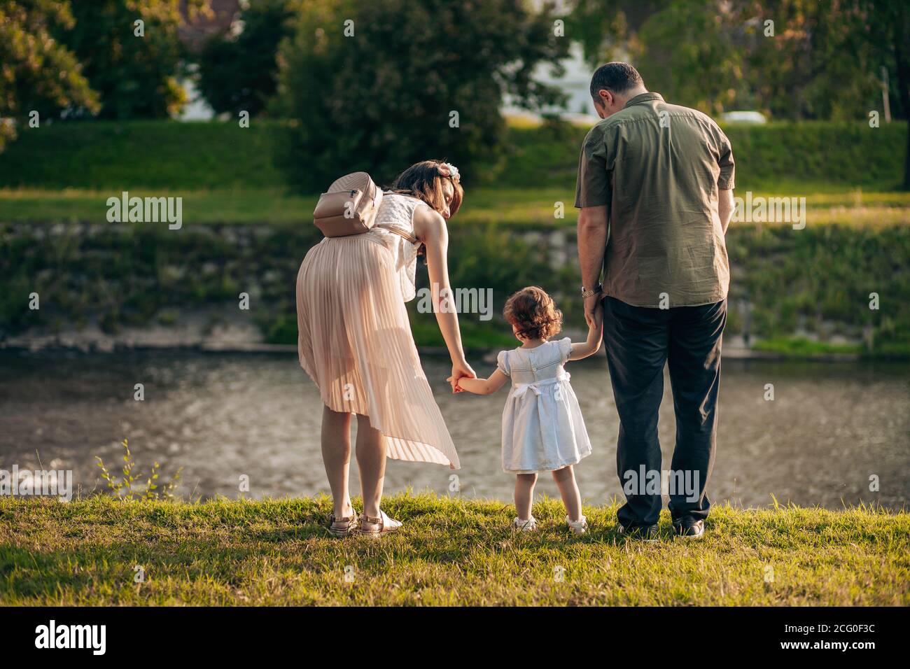 Happy family, mother, father and little daughter have fun outdoors Stock Photo