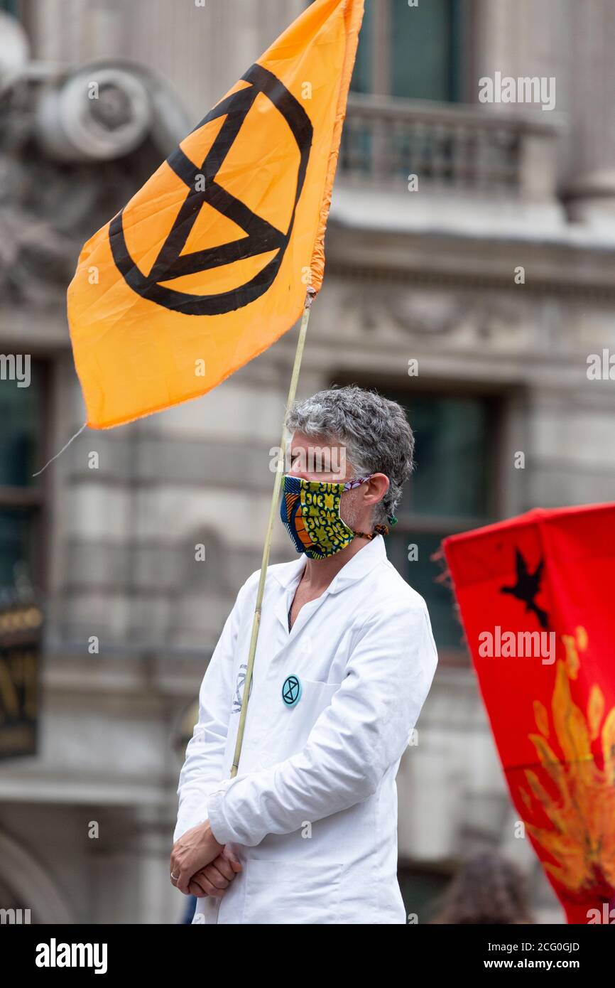 Protester with flag, 'Walk of Shame' Extinction Rebellion demonstration, Bank of England, London, 4 September 2020 Stock Photo