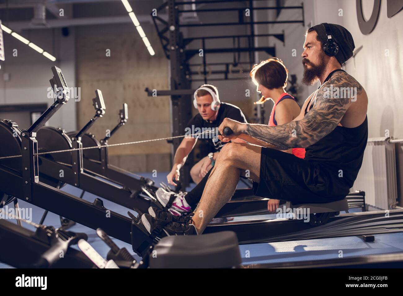 Mid section of people exercising on rowing machine at gym Stock Photo