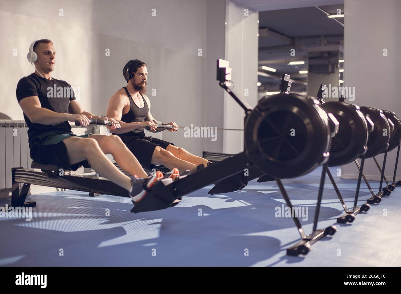 Mid section of people exercising on rowing machine at gym Stock Photo