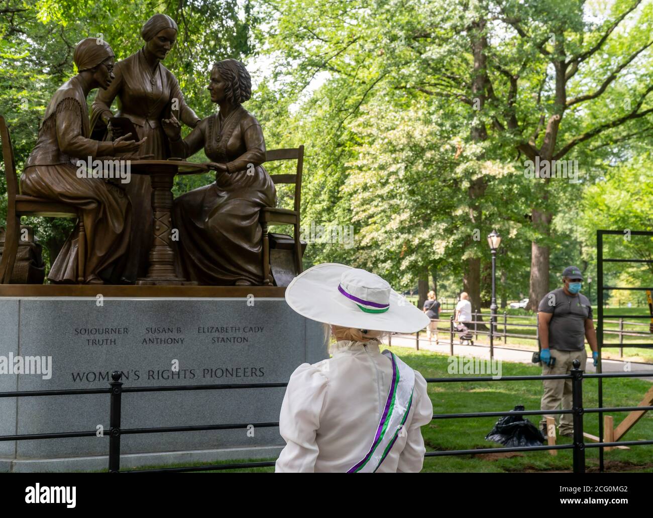 People cluster around the Women’s Rights Pioneer Monument on Literary