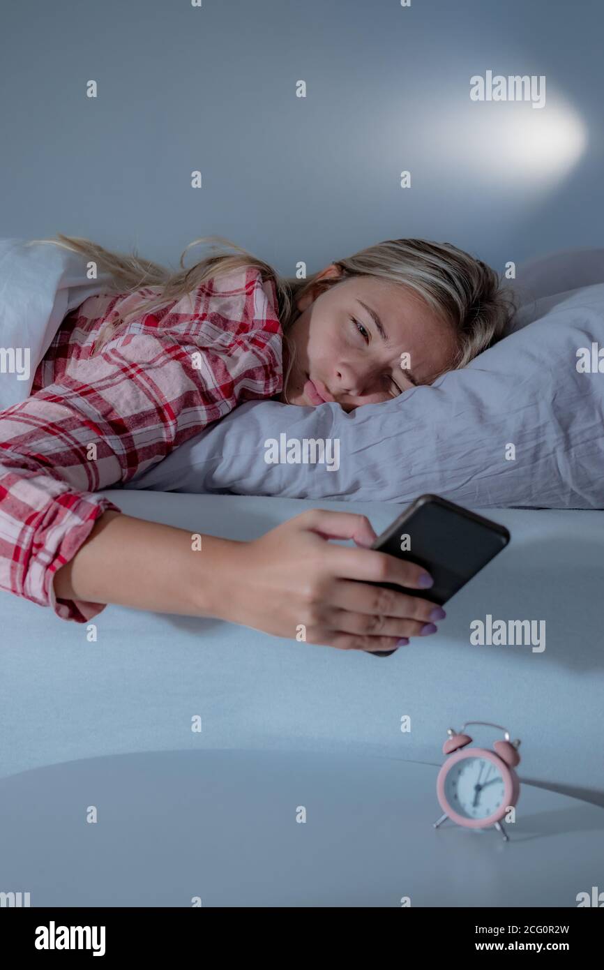 I have a hard time getting up in the morning Beautiful Young Woman In Pajamas Sleeping In Bed Turning Off The Alarm Clock On A Mobile Phone Having A Hard Time To Wake Up In The Morning Stock Photo Alamy