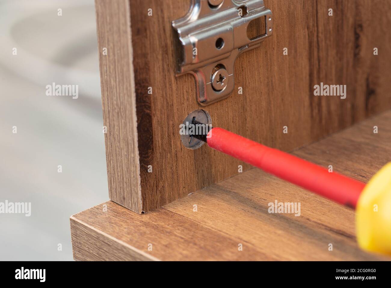 Flat pack wooden being assembled with a screwdriver. Self